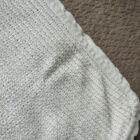 Baby wrapped in white cotton baby knit blanket
