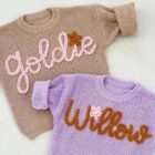 chunky knit baby sweater embroidered letter back view flat lay product photo