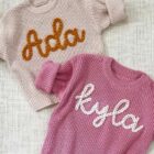 chunky knit baby sweater embroidered letter side view or detail closeup photo