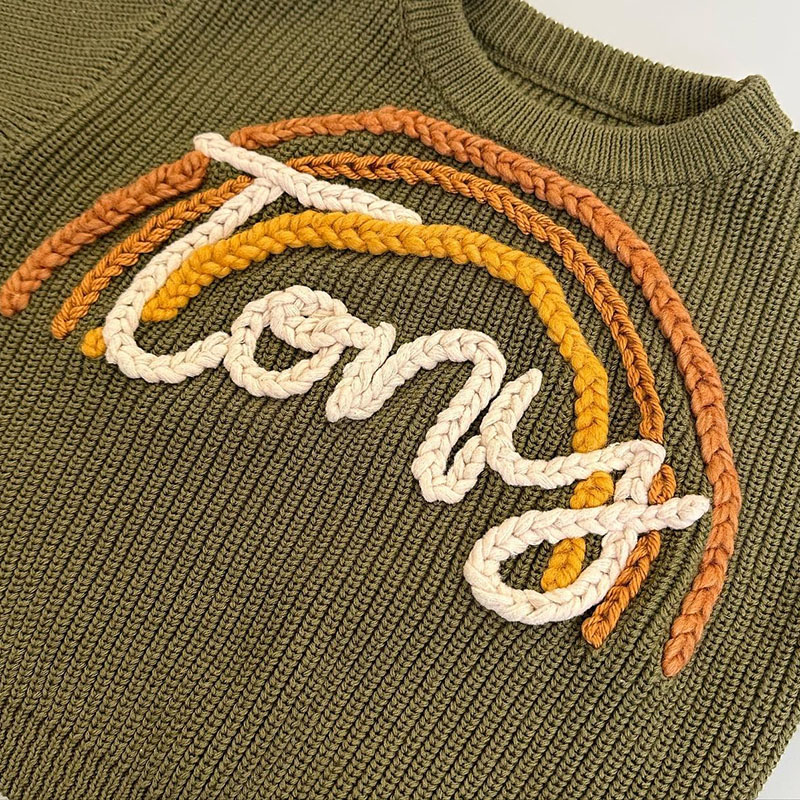 chunky knit baby sweater embroidered letter texture and fabric detail photo
