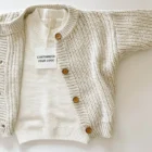 speckled chunky knit cardigan baby sweater front view flat lay product photo