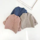 plain knitted infant baby cardigan sweater front view flat lay product photo