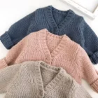 plain knitted infant baby cardigan sweater side view or detail closeup photo