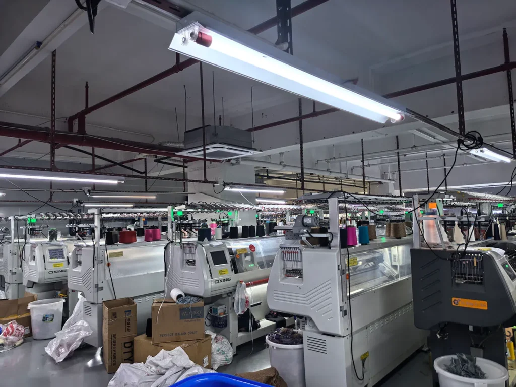 HDL Fashion knitting workshop equipped with rows of computerized flat knitting machines.