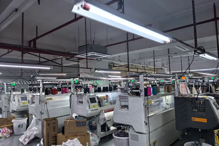HDL Fashion knitting workshop equipped with rows of computerized flat knitting machines.