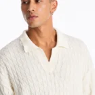 Close-up of the open V neck collar and cable knit texture on the cotton sweater