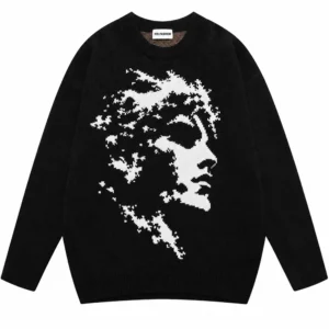 Black cotton jacquard knit sweater laid flat showing the knitted portrait pattern on the front