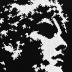 Close-up of the knitted jacquard stitch detail forming the portrait pattern on the sweater
