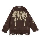 Brown crew neck sweater with STRACORE in cream gothic lettering above two dagger motifs, with long loose yarn loops at cuffs and hem