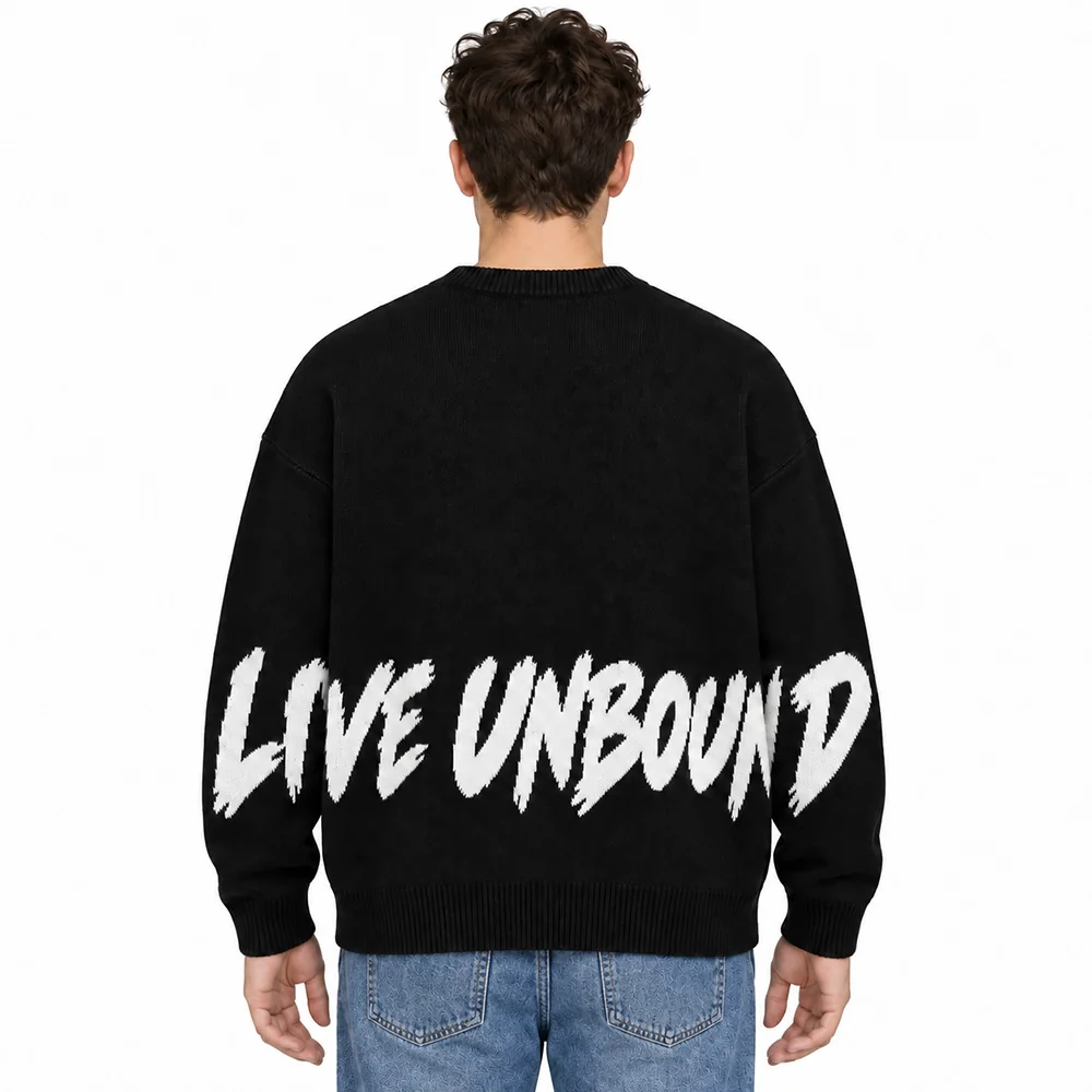 Male model wearing the black slogan jacquard sweater, back view with LIVE UNBOUND slogan