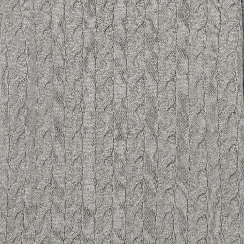 Close-up of gray knitted fabric with repeating vertical cable patterns.